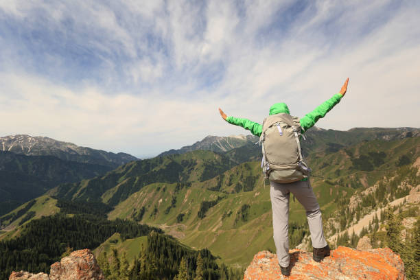 istock cheering successful woman backpacker open arms on mountain peak 640306710