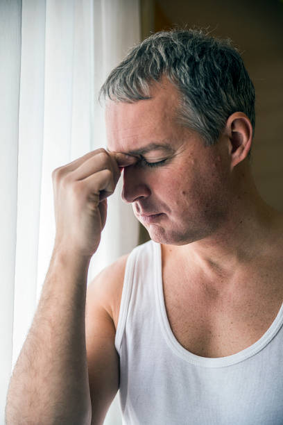 istock man looking through window looking worried, depressed, thoughtful and lonely 640309126
