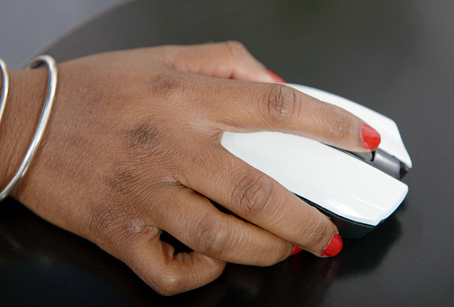 Close-up of the hand of a young African woman with a mouse