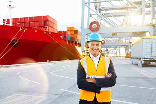 Portrait of a mature man in workwear standing in a large commercial dock