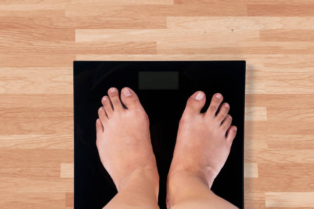 istock Female barefoot and weight scale 640315134