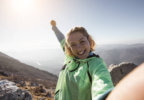 wanderer, der ein selfie auf dem gipfel des hügels macht - climbing women sport mountain stock-fotos und bilder