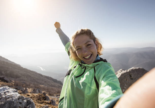 randonneur prenant un selfie au sommet de la colline - climbing women sport mountain photos et images de collection