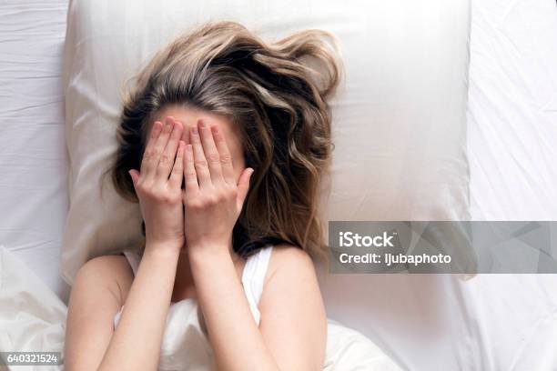 She Is Covering Her Head With Her Hands In Bed Stockfoto en meer beelden van Slapeloosheid - Slapeloosheid, Volwassen vrouwen, Wakker worden