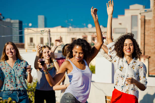 istock Happy friends dancing and drinking wine at rooftop party 640322574