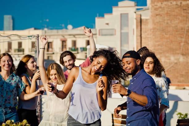 istock Happy friends dancing and drinking wine at rooftop party 640322854