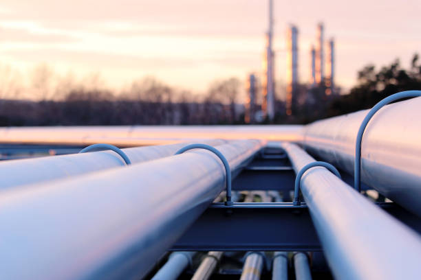 steel long pipes in crude oil factory during sunset stock photo