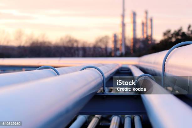Steel Long Pipes In Crude Oil Factory During Sunset Stock Photo - Download Image Now