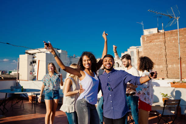 istock Happy friends dancing and drinking wine at rooftop party 640322994