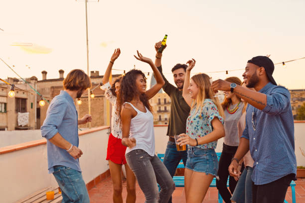 Multi ethnic friends dancing at the rooftop party