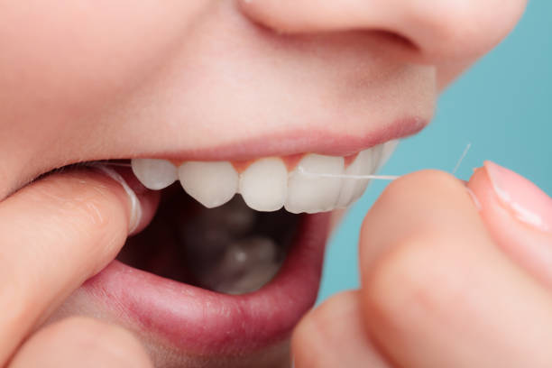 istock side view woman face smiling with dental floss. 640325588