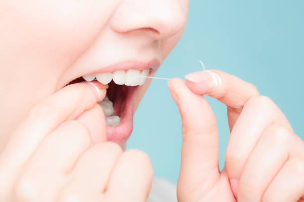 istock side view woman face smiling with dental floss. 640325616