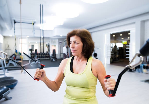 istock Senior woman in gym working out with weights. 640325638