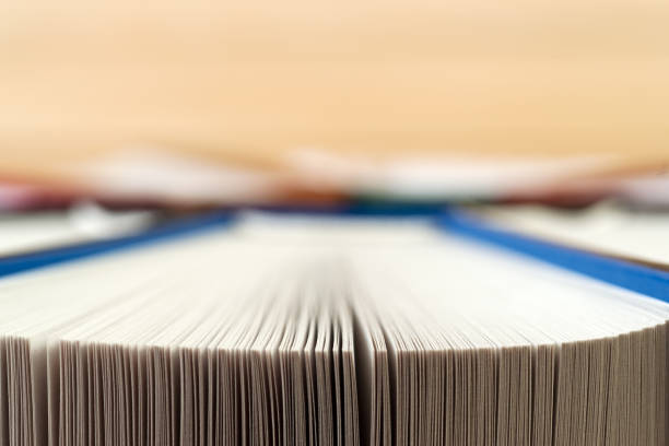 istock Open book, stack of hardback books on wooden table. 640330000
