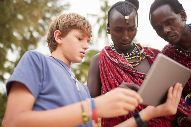 istock Boy teaching Maasai warriors to use a digital tablet. 640332110