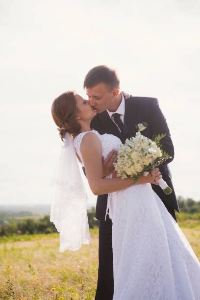 istock couple bride and groom on field background 640332712