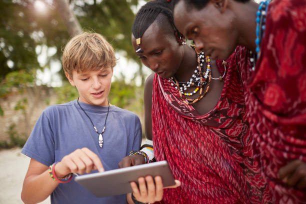 istock Boy teaching Maasai warriors to use a digital tablet. 640333192