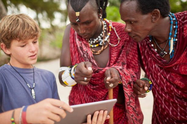istock Boy teaching Maasai warriors to use a digital tablet. 640333286