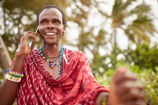 Elegant Maasai man using a smartphone. Elegant Maasai man using a smartphone. kenyan man stock pictures, royalty-free photos & images