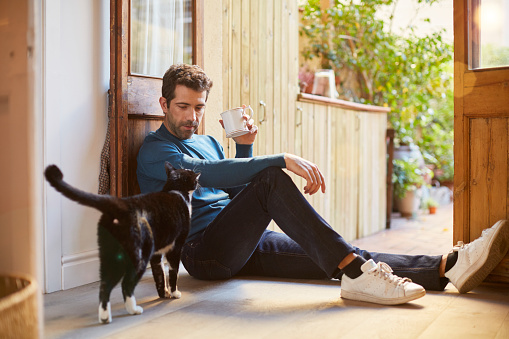 Enjoying a cup of tea sitting on the ground. Lifestyle shot in real location, Spain.