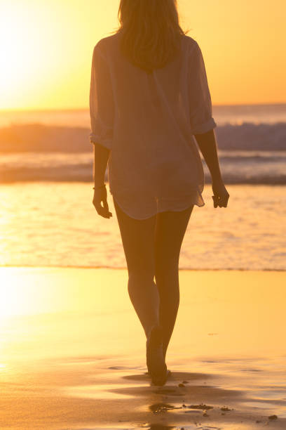 istock Lady walking on sandy beach in sunset. 640336090