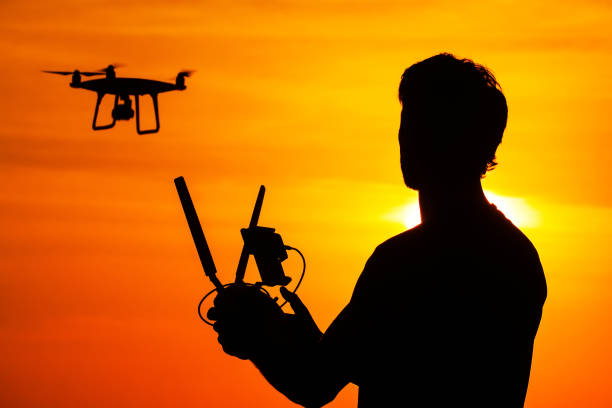 istock Silhouette of man operating drone 640336268