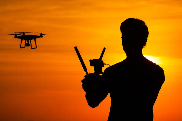 istock Silhouette of man operating drone 640337216