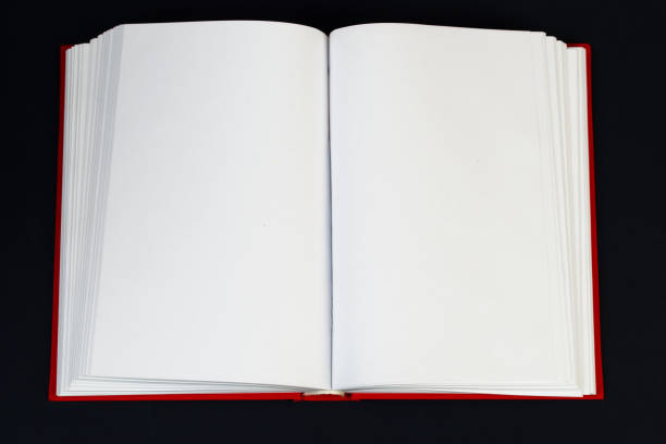istock Open hardback book on wooden table. 640341938