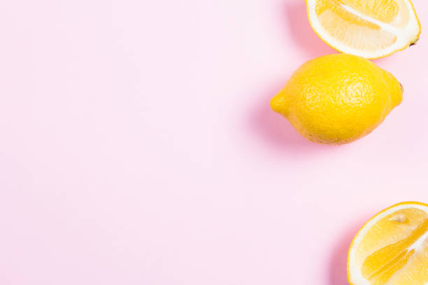 istock Whole and sliced lemon on pink background 640342056