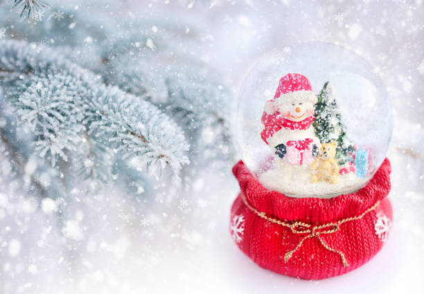 istock Snow globe with snowman on a background snow-covered fir branches 640345878