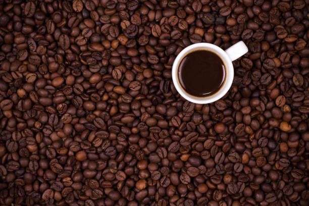 Coffee beans background with white cup stock photo