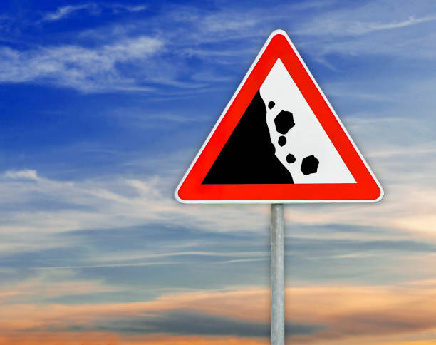 istock Triangle road sign falling rocks on rod with cloudy sky 640349048
