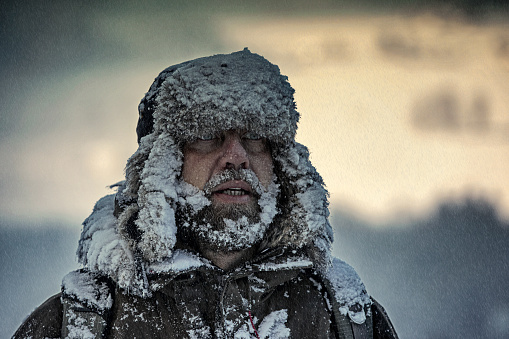 Portrait of man outside in winter snowstorm