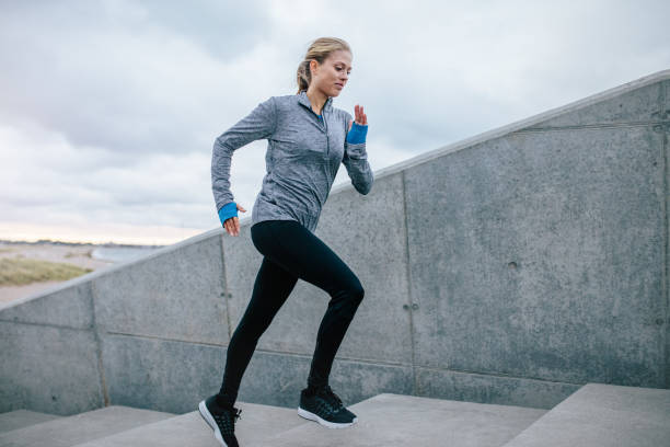 istock Young woman running alone up stairs 640352044