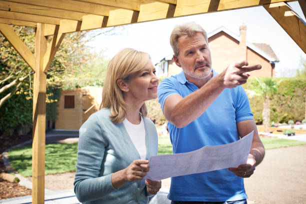 reife frau diskutieren plan mit landschaftsgärtner - gartenarchitekt stock-fotos und bilder