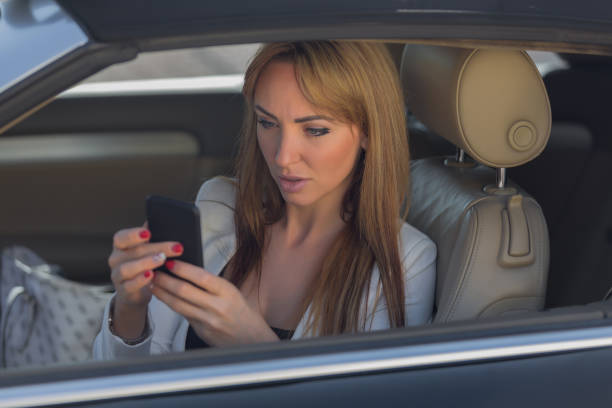 istock Businesswoman using smart phone in a car 640354682