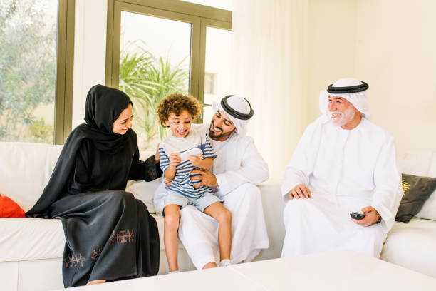 famiglia araba felice di tre generazioni a casa - abbigliamento modesto foto e immagini stock