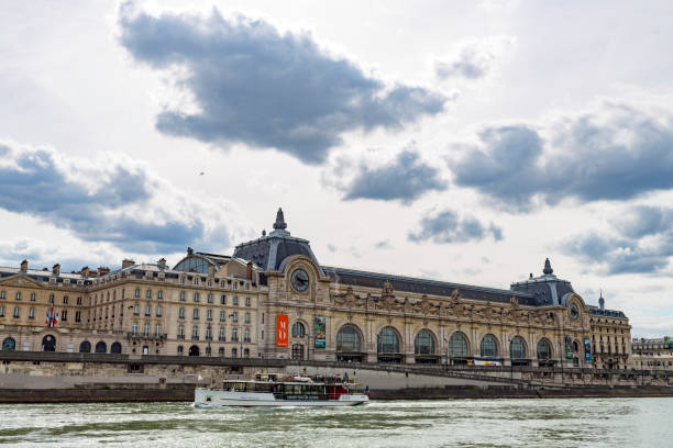 Tourist boat in Paris on the Seine River With Musee Dorsay Paris, France - April 27, 2016: Tourist boat on the River Seine passing by the Musee Dorsay Paris, France musee dorsay stock pictures, royalty-free photos & images