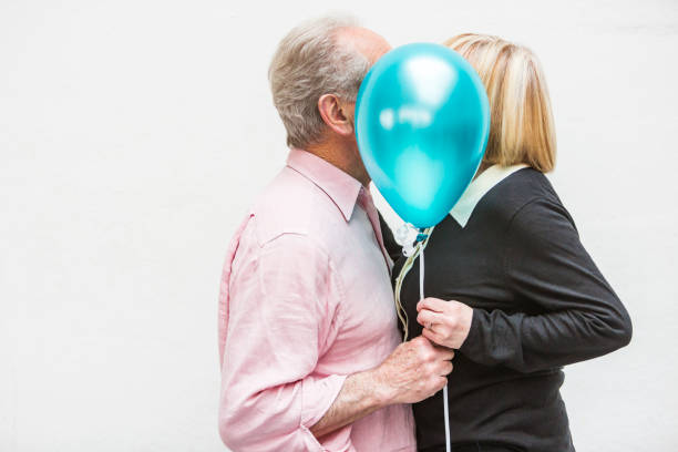 Loving Happy Active Senior Couple Playing With Balloons