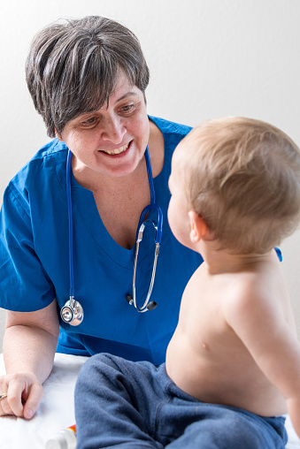 Baby boy posing near his female pediatrician