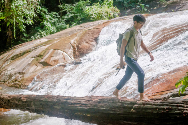 istock Businessman with backpack and laptop and phone at  waterfall  the forest. 640832322