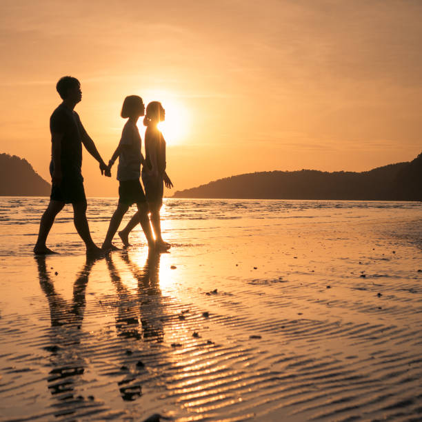 istock happy family walking on the beach 640832948
