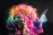 Woman splashing hair with holi powder