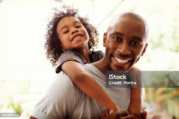 Feliz Padre Hijo En La Yarda De Piggybacking Foto de stock y más banco de imágenes de Hijo - Hijo, Padre, Familia