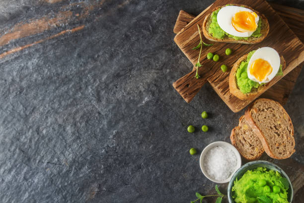 istock Baguette with mashed green peas, eggs and mint. Dark background. 640890378