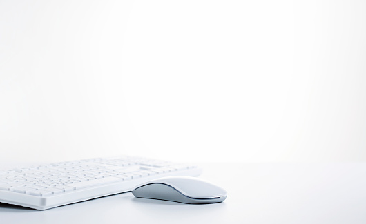 White simple computer keyboard and mouse with large copy space.