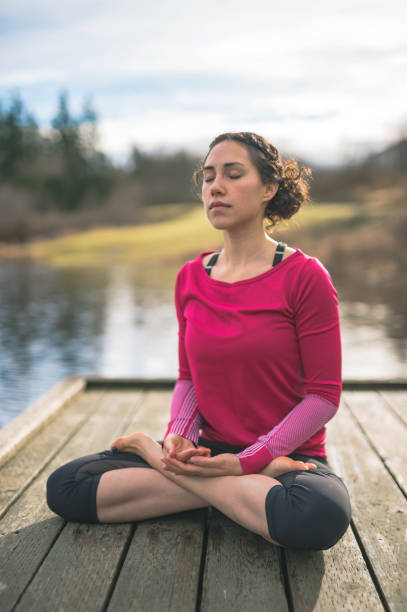 istock Young mom doing yoga outside by lake 640900018