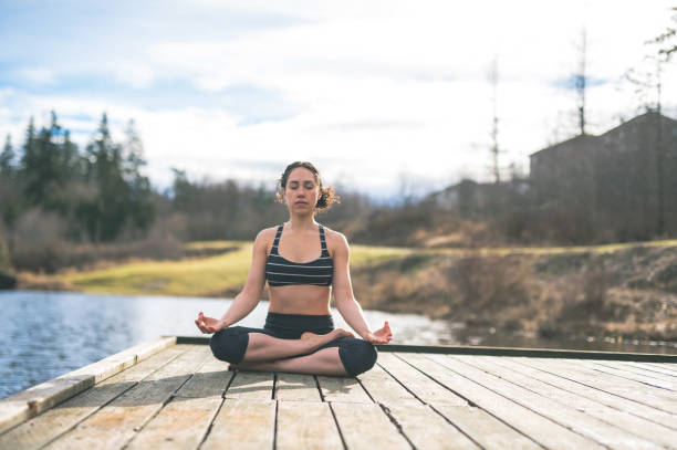 istock Young mom doing yoga outside by lake 640900028