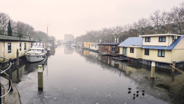 Traditional Dutch floating houses on freezing canal in Schiedam, Netherlands stock photo