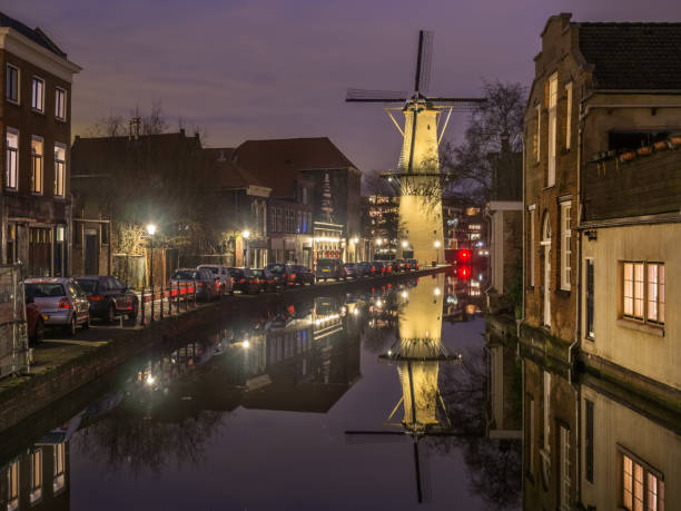 Old Dutch city Schiedam landscape during calm weather with reflections in a canal and old windmill stock photo